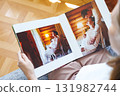 woman is holding and flipping through a photo book with a pregnancy photo shoot 131982744