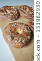 Freshly baked bagels topped with mixed seeds on a wooden board 131982930