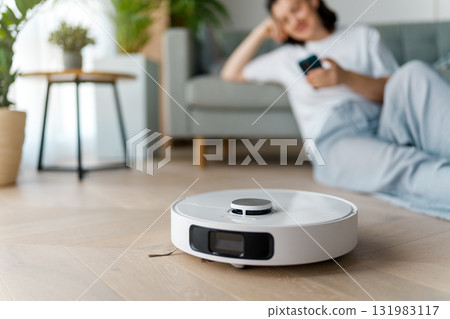 White robotic vacuum cleaner on wooden floor White robotic vacuum cleaner on wooden floor 131983117