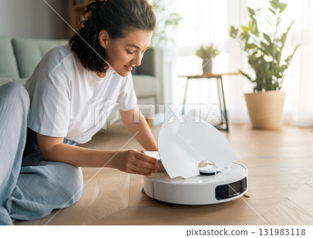 White robotic vacuum cleaner on wooden floor 131983118