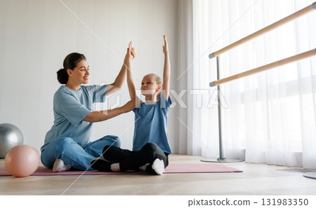 girl doing exercises under doctor's supervision girl doing exercises under doctor's supervision 131983350