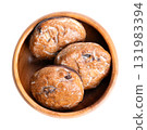 German Lebkuchen, Christmas cookies, in wooden bowl. Traditional spice cookies, similar to gingerbread, circle shaped, sugar glazed, with candied fruit pieces, dipped in dark chocolate at the bottom. 131983394