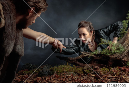 The young man rescues the girl by holding out his hand to her. 131984003