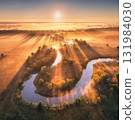 Aerial view of beautiful curving river in low clouds at sunrise 131984030
