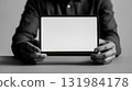 Hands holding digital tablet with blank white screen in black and white style 131984178