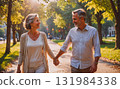 Man and woman are running together on a path in a forest. The man is wearing a blue shirt and shorts, while the woman is wearing a pink tank top and black pants. Scene is energetic and active 131984338
