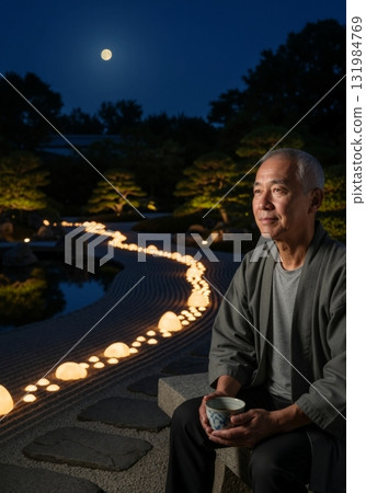 Elderly Asian man contemplating in a Japanese zen garden at night. Senior male holding tea under a full moon. Tranquil retirement and mindfulness concept 131984769