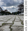 stone paving stones stretching into the distance along the houses against the background of low clouds 131985340