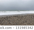 The turbulent sea storms the shore of sand mixed with pebbles 131985342