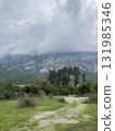 Low fluffy clouds hang over the high mountains, cover their peaks 131985346