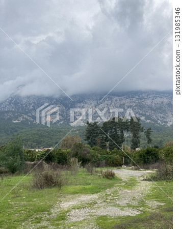 Low fluffy clouds hang over the high mountains, cover their peaks Low fluffy clouds hang over the high mountains, cover their peaks 131985346