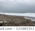 The turbulent sea storms the shore of sand mixed with pebbles 131985351