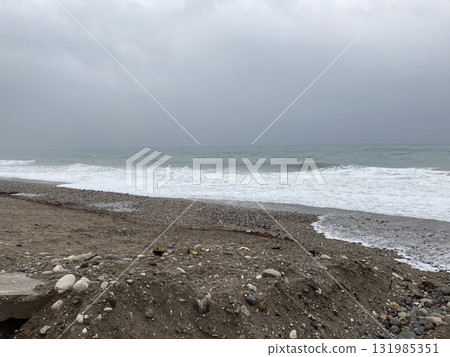 The turbulent sea storms the shore of sand mixed with pebbles The turbulent sea storms the shore of sand mixed with pebbles 131985351