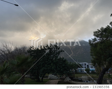 Low fluffy clouds hang over the high mountains, cover their peaks 131985356