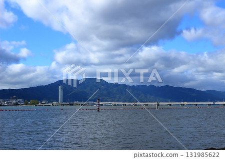 Mount Hiei seen across Lake Biwa with large clouds hanging above 131985622