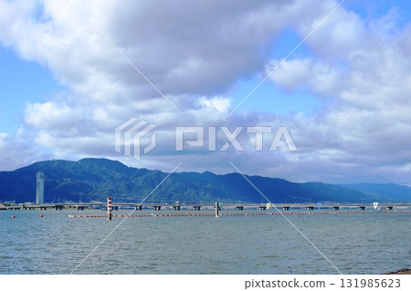 Mount Hiei seen across Lake Biwa with large clouds hanging above 131985623