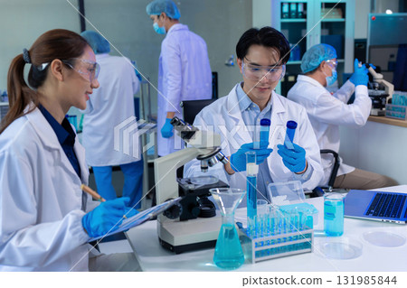 Lab work, Doctor holds a test tube takes the test from a test tube in analysis, blood, DNA, test tube stand. 131985844