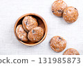 German Lebkuchen, Christmas cookies, in a wooden bowl on linen. Traditional spice cookies, similar to gingerbread, sugar glazed, with candied fruit pieces, dipped in dark chocolate at the bottom. 131985873