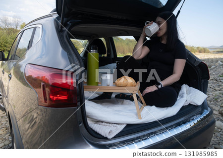 Woman Relaxing in Car Trunk in Nature Woman Relaxing in Car Trunk in Nature 131985985