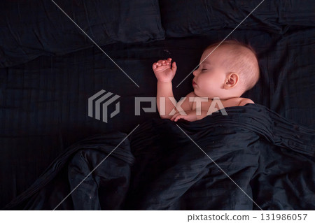 Peaceful baby sleeping on dark bedding Peaceful baby sleeping on dark bedding 131986057