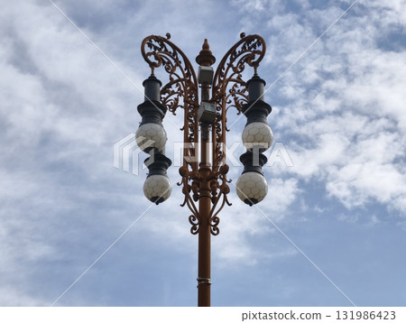 An Elegant Vintage Street Lamp Set Against a Beautiful Blue Sky During Daylight Hours An Elegant Vintage Street Lamp Set Against a Beautiful Blue Sky During Daylight Hours 131986423