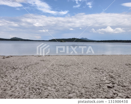 A Beautiful and Serene Beach Landscape that showcases Calm Waters and Soft Clouds in the Sky above A Beautiful and Serene Beach Landscape that showcases Calm Waters and Soft Clouds in the Sky above 131986438