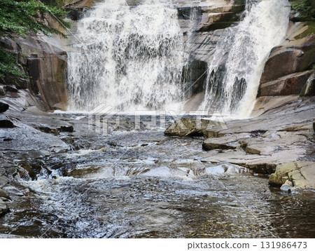 A Majestic Waterfall Cascades Beautifully Over Rocks Surrounded by Natures Splendor A Majestic Waterfall Cascades Beautifully Over Rocks Surrounded by Natures Splendor 131986473