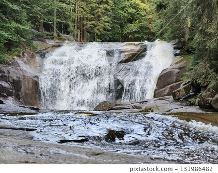 A Stunning Waterfall Gracefully Surrounded by Lush Greenery in the Heart of Nature 131986482