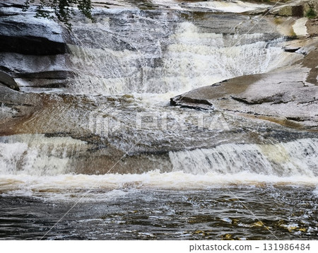 A Serene and Stunning Waterfall Cascading Gracefully Over Rocks in a Picturesque Nature Scene A Serene and Stunning Waterfall Cascading Gracefully Over Rocks in a Picturesque Nature Scene 131986484