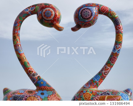 A Pair of Colorful Artistic Swans Gracefully Facing Each Other in Serene Harmony A Pair of Colorful Artistic Swans Gracefully Facing Each Other in Serene Harmony 131986494