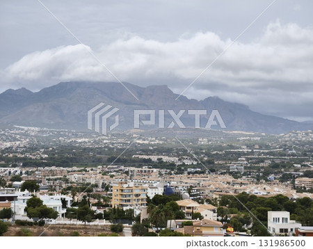 A Scenic and Beautiful View of Majestic Mountains and Charming Town under a Cloudy Sky A Scenic and Beautiful View of Majestic Mountains and Charming Town under a Cloudy Sky 131986500