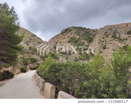 A scenic pathway winds through a breathtaking landscape, inviting nature lovers to explore A scenic pathway winds through a breathtaking landscape, inviting nature lovers to explore 131986517