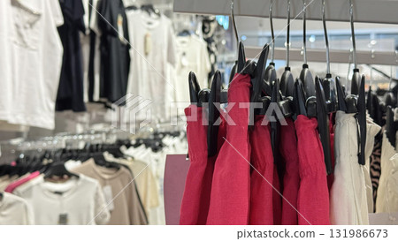 A clothing rack displays red and white garments in a modern fashion store 131986673
