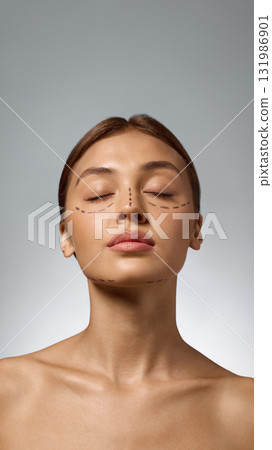 Woman with face markings and closed eyes showing calm trust before cosmetic procedure Woman with face markings and closed eyes showing calm trust before cosmetic procedure 131986901