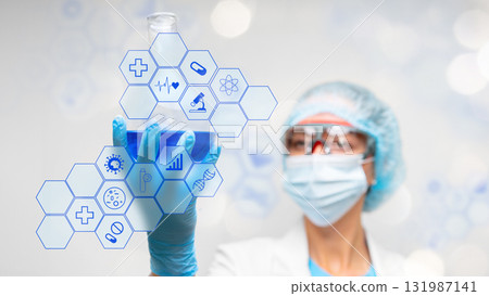 Scientist holds blue liquid in a flask while examining digital health icons 131987141