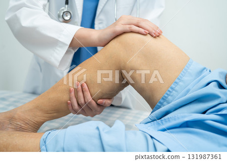 Doctor checking Asian elderly woman patient with scar knee replacement surgery in hospital. Doctor checking Asian elderly woman patient with scar knee replacement surgery in hospital. 131987361