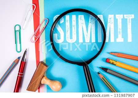 Summit concept with magnifying glass over word summit on blue background surrounded by office 131987907
