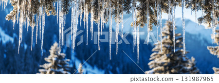 Icicles shine under the evening sky as sunlight filters through snow-covered trees in a serene winter forest. Tracks in the snow lead deeper into the tranquil scene, banner 131987965