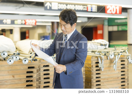 A middle-aged man in a suit managing the event A middle-aged man in a suit managing the event 131988310