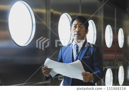 A middle-aged man in a suit managing the event 131988316