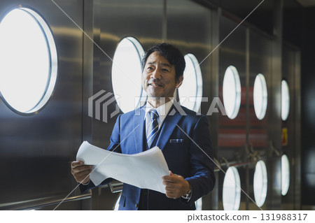 A middle-aged man in a suit managing the event 131988317