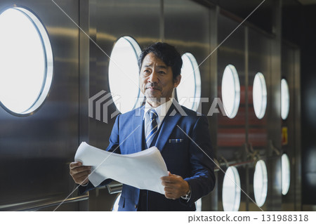 A middle-aged man in a suit managing the event A middle-aged man in a suit managing the event 131988318