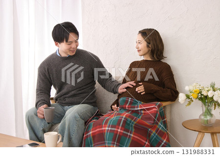 一對年輕夫婦在沙發上休息，孕婦 131988331