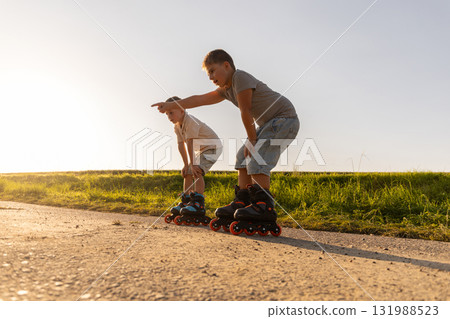 Two friends are inline skating during a sunny afternoon. They are having fun together, enjoying the warm weather and the beautiful natural surroundings Two friends are inline skating during a sunny afternoon. They are having fun together, enjoying the warm weather and the beautiful natural surroundings 131988523