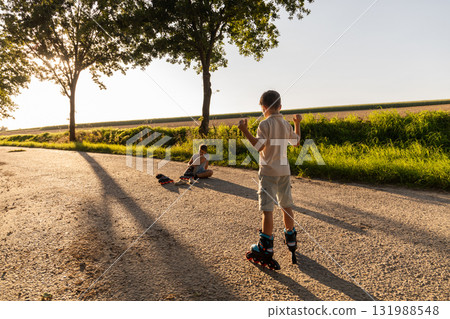Two friends enjoy inline skating on a sunny afternoon in a peaceful outdoor setting, surrounded by trees and open fields, making the most of their free time Two friends enjoy inline skating on a sunny afternoon in a peaceful outdoor setting, surrounded by trees and open fields, making the most of their free time 131988548