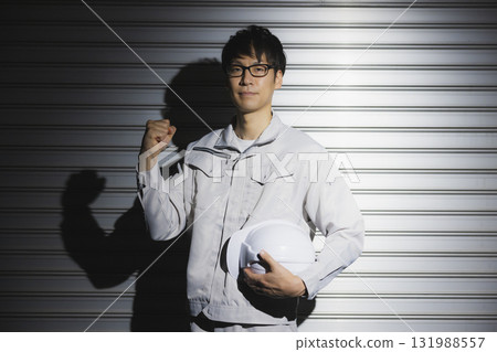 一名身穿工作服、戴著頭盔的男子 一名身穿工作服、戴著頭盔的男子 131988557