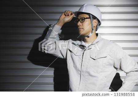A man in work clothes wearing a helmet 131988558