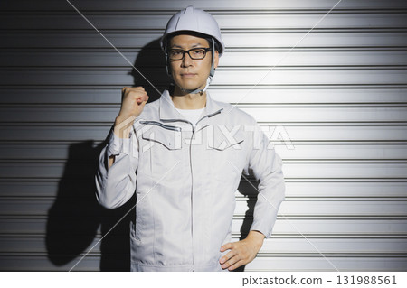 A man in work clothes wearing a helmet 131988561