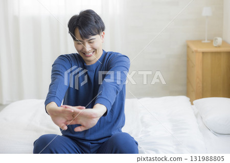 Man stretching in bed Man stretching in bed 131988805