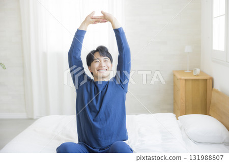 Man stretching in bed Man stretching in bed 131988807